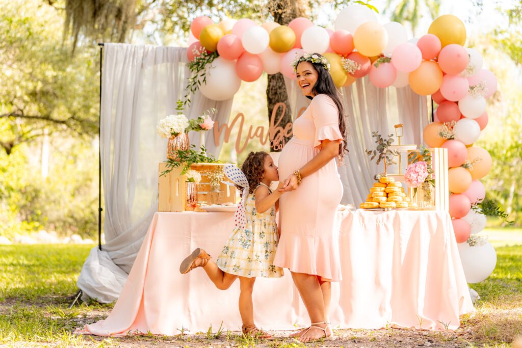 little girl kissing pregnant lady's stomach